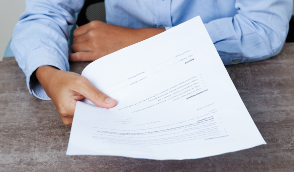 person with a magnifying glass looking through contract 